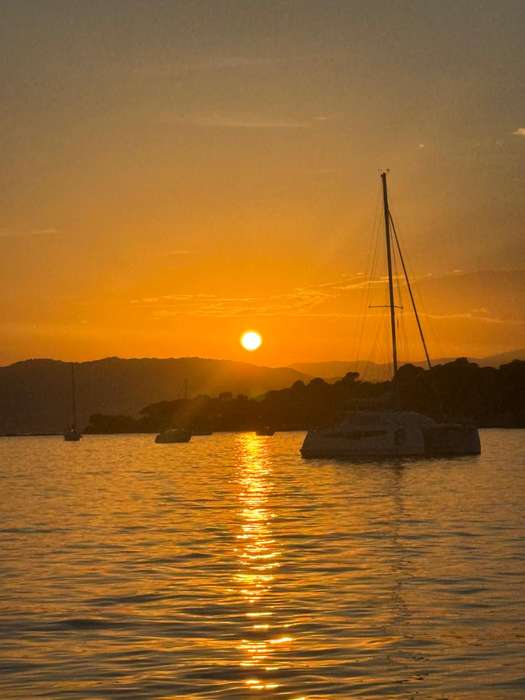 Coucher de soleil sur la mer devant un voilier à l'ancre près du Cap d'Antibes